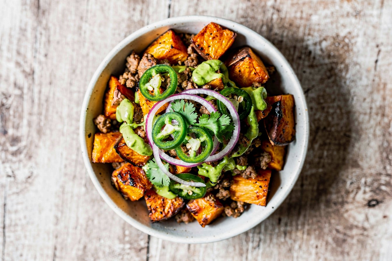 Hack-Süßkartoffel-Bowl mit grüner Kräutersauce